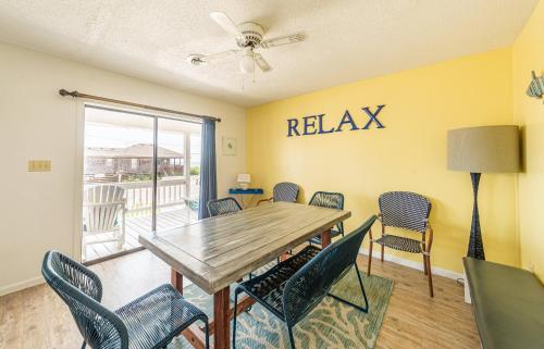a dining room with a table and chairs and a balcony at Out of the Blue in Kitty Hawk