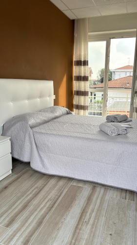a bedroom with a bed and a large window at Elco Rooms Malpensa in Lonate Pozzolo