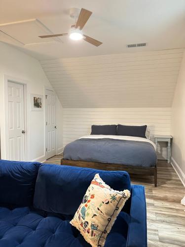 a living room with a bed and a blue couch at Charming Chic Charleston & DI Loft Getaway in Charleston