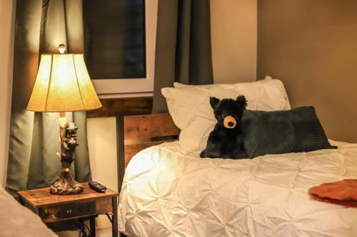 a black dog laying on top of a bed at Refined 6br Moose & Bear Lodge By Sweetheart Stay in Livingston