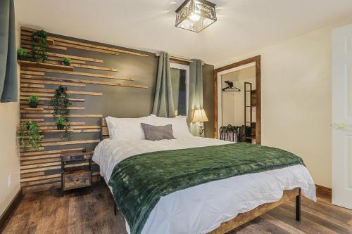 a bedroom with a large bed with a green blanket at Refined 6br Moose & Bear Lodge By Sweetheart Stay in Livingston