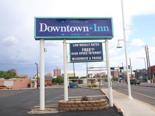 a sign in a parking lot next to a street at Downtown Inn in Albuquerque