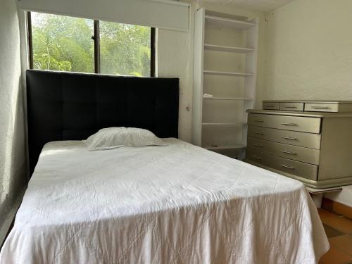 a bedroom with a bed and a dresser and a window at El Rincón De La Abuela Paisaje y Confort in La Cumbre