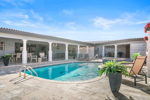 a swimming pool with a patio and a house at Scobillostraat 27 in Rooi Bosal