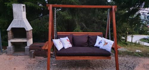 a porch swing with three pillows on it at The mountain house Dora in Kochani
