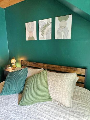a bedroom with a green wall and a bed with two pillows at Cozy 1bd apartment in the heart of Liverpool NY in Liverpool