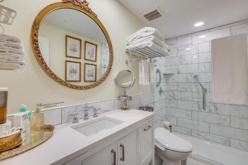 a bathroom with a sink and a mirror and a toilet at Hot Tub and Fenced Yard Cozy Cottage Grove Home in Cottage Grove