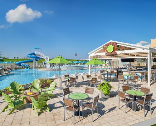 a patio with tables and chairs next to a pool at Margaritaville Hotel Kansas City in Kansas City