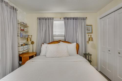 a bedroom with a bed with white sheets and a window at Hot Tub and Fenced Yard Cozy Cottage Grove Home in Cottage Grove