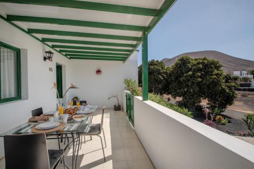 ヤイサにあるCasa de La Huerta by Villalizeのバルコニーにテーブルと椅子が置かれたパティオ