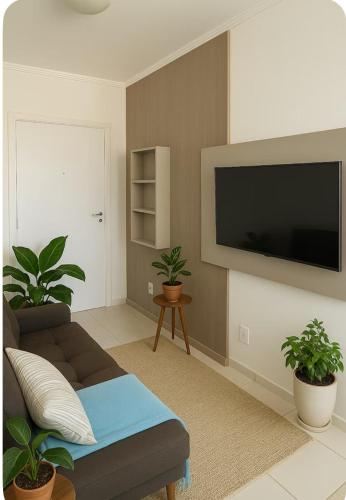 Una sala de estar con un sofá y un televisor de pantalla plana. en Refúgio Urbano - central c garagem, en Santa Maria