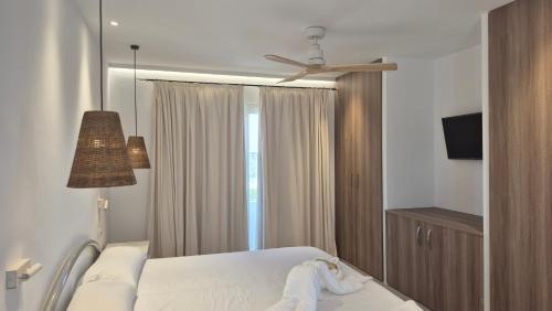 een slaapkamer met een bed en een plafondventilator bij Apartamentos Casa Romantica in La Savina