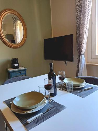 a table with two plates and wine glasses on it at Suite Vino e Palio in Asti