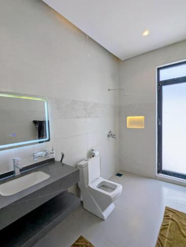 a bathroom with a toilet and a sink and a mirror at Amour Beach Villas in Paje