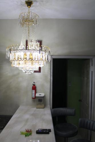 a dining room with a chandelier and a table at Cozy Vibes in Portmore