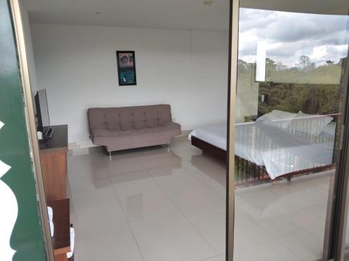 a living room with a couch and a window at Finca Hotel la Manuela in Armenia