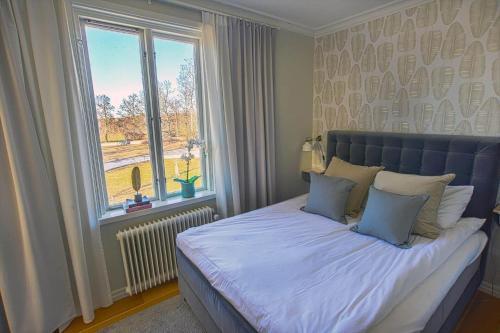 a bedroom with a large bed with a window at KAL791-Vimmerby-Fredensborg-120 in Storebro