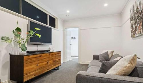 a living room with a couch and a tv at Relaxing Family Retreat with Outdoor Entertaining in Golden Square