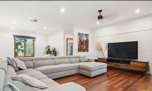 a living room with a couch and a flat screen tv at Relaxing Family Retreat with Outdoor Entertaining in Golden Square