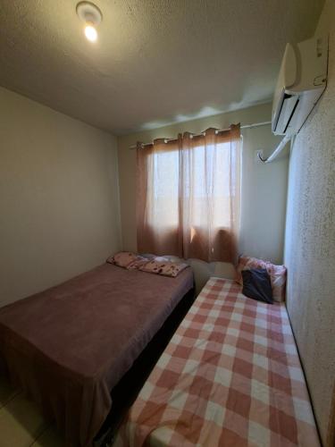 a small bedroom with a bed and a window at Apartamento para COP 30 in Marituba