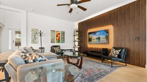 a living room with a couch and a ceiling fan at 6BR Luxury Home with Private Pool and BBQ in Kissimmee
