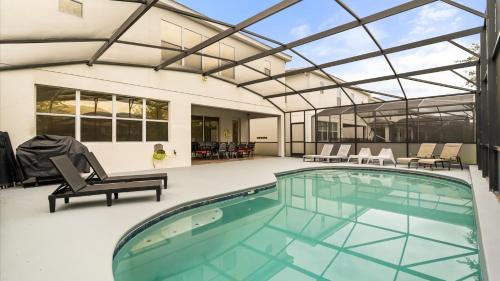 an indoor swimming pool with a glass roof at 6BR Luxury Home with Private Pool and BBQ in Kissimmee