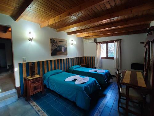 ein Schlafzimmer mit zwei Betten und einer Holzdecke in der Unterkunft Casa del arroyo in Villa General Belgrano