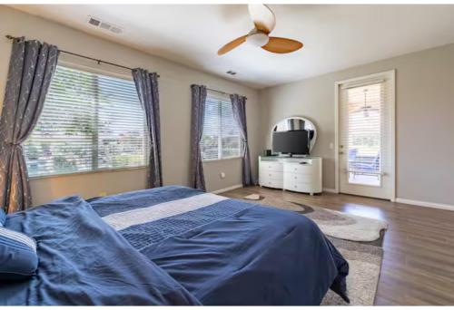 a bedroom with a bed and a ceiling fan at Lakefront 3BR Indio Retreat with Backyard and Games in Indio
