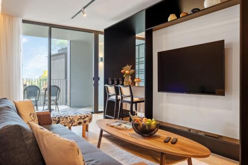 a living room with a couch and a tv at Infinity Pool and Open Views at Savoy Insular in Funchal