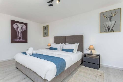 a bedroom with a large bed with a blue blanket at Indigo - Duplex 1-BR Apt with Terrace & Garden in Batroun in Al Ḩulwah
