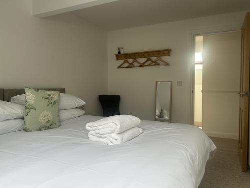 a bedroom with a white bed with towels on it at Richmond, Keswick town centre apartment in Keswick