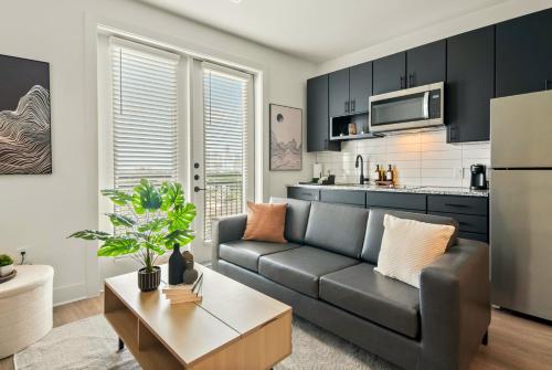 a living room with a couch and a kitchen at Stylish New Studio DT - Pool, Gym - Rooftop Lounge in Houston