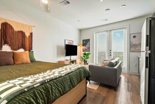 a bedroom with a bed and a chair and a television at Stylish New Studio DT - Pool, Gym - Rooftop Lounge in Houston