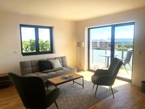 a living room with a couch and a table and chairs at Apartmány JARO Mladá Boleslav in Bradlec