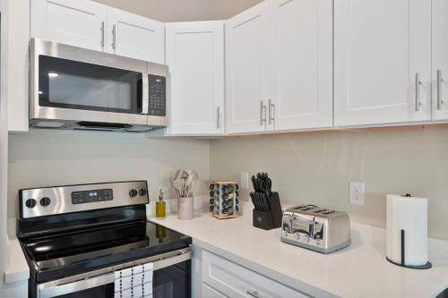 a kitchen with white cabinets and a microwave at Desert Oasis - Lux Suite w Pool by Stadium - Golf in Surprise