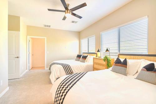 a bedroom with two beds and a ceiling fan at Cozy Cactus - 5 Bed Suite w Pool - Stadium - Golf in Surprise
