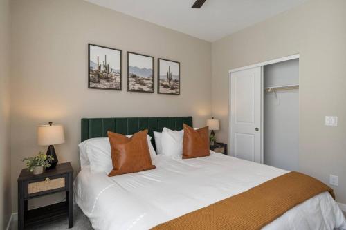 a bedroom with a large bed with a green headboard at Cozy Cactus - 5 Bed Suite w Pool - Stadium - Golf in Surprise