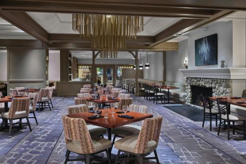 a dining room with tables and chairs and a fireplace at Salt Lake Marriott Downtown at City Creek in Salt Lake City