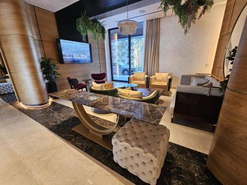 a lobby with a table and chairs and a living room at Apartment Rajski 717 in Zlatibor