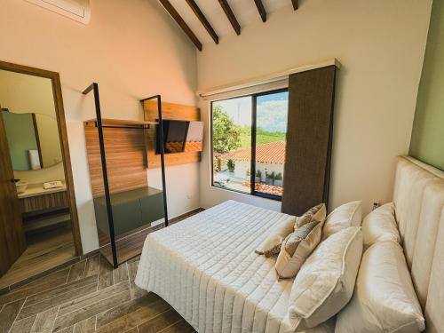 a bedroom with a bed and a couch and a window at Antara Resort in Alcalá