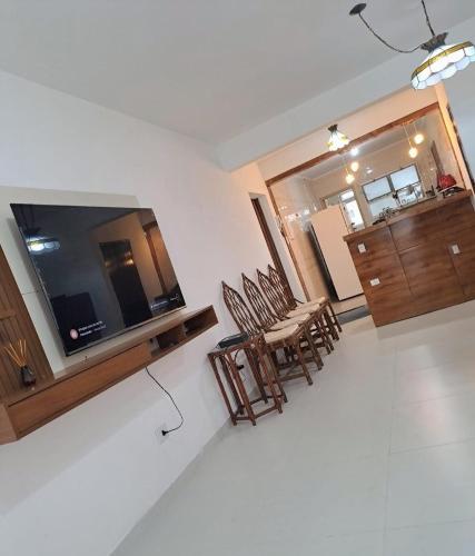 ein Wohnzimmer mit Tisch und Stühlen und einem Fernseher in der Unterkunft Recanto da Felicidade in Guarujá