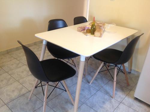 a table with four chairs and a bottle of wine at Villa Sofia in Chrani