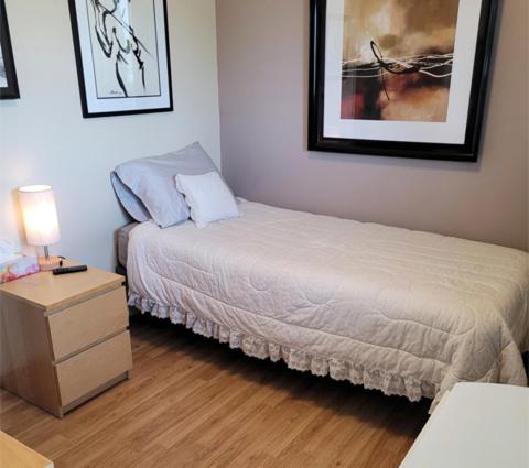 une petite chambre avec un lit et une table de chevet dans l'établissement The Dewberry Homestay B&B, à Edmonton