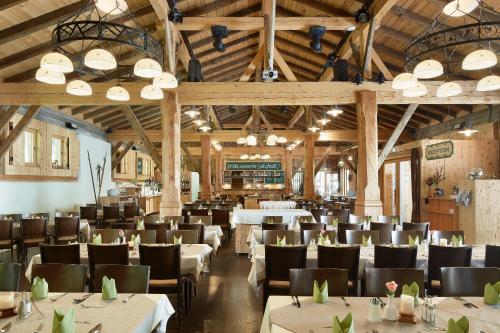 a dining room with tables and chairs and wooden ceilings at Gasthof Salzstadl in Reutte