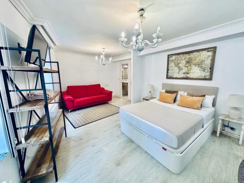 a bedroom with a bed and a red couch at Mirador Catedral de Santiago in Bilbao