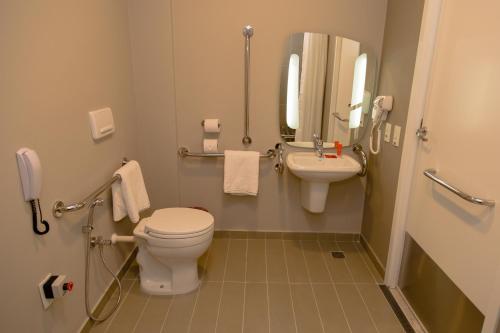 a bathroom with a toilet and a sink at Ibis Lorena - Circuito da Fé in Lorena