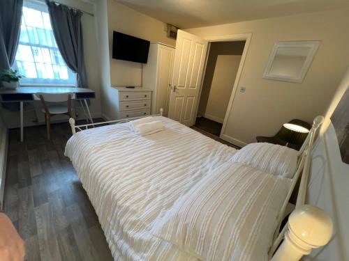 a bedroom with a white bed and a desk at Town apartment in Shifnal