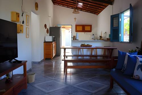 ein Wohnzimmer mit Tisch und Küche in der Unterkunft Casa charmosa em BG - Casa Trevo in Barra Grande