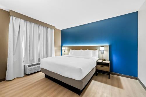 a large bed in a room with a blue wall at Comfort Suites Texarkana Texas in Texarkana - Texas