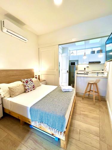 a bedroom with a large bed and a kitchen at Casa Rambla Serra Cali in Cali